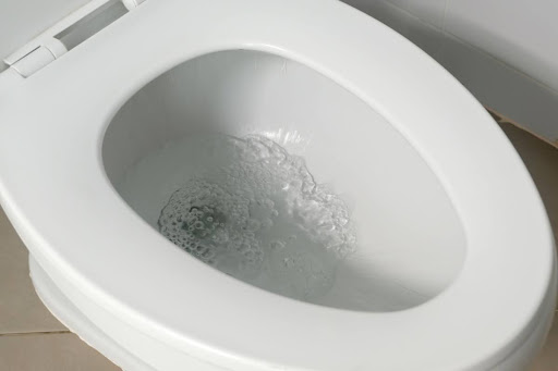 Water flushing in a toilet bowl.