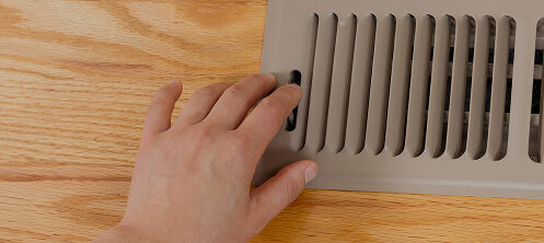 Person opening or shutting a floor vent