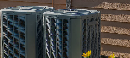 Outdoor air conditioning units sitting side-by-side in Central Wisconsin