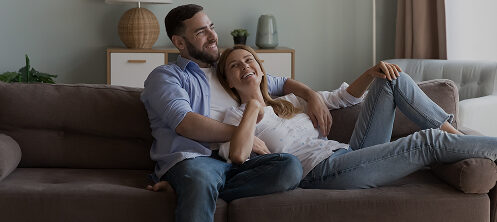 Happy couple sitting on a couch in their Central Wisconsin home
