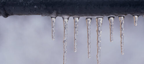 Frozen pipe with icicles hanging down in Central WI