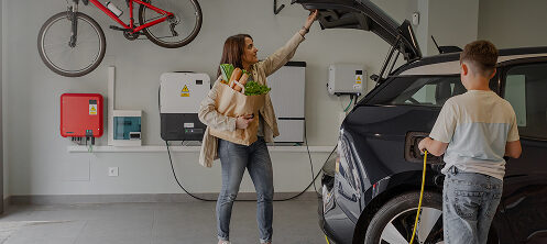 Mom shutting the trunk of her EV while charging the car