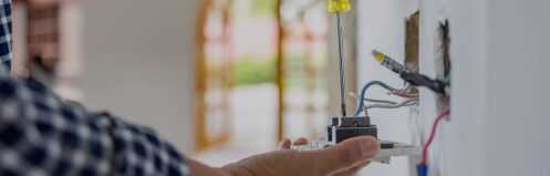 Close-up on an electrician installing a power outlet while remodeling a house