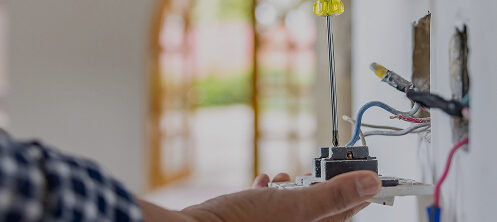 Close-up on an electrician installing a power outlet while remodeling a house