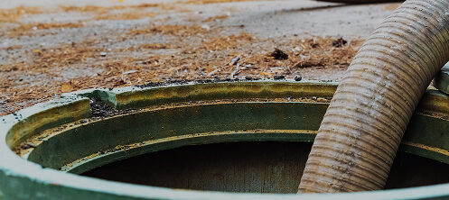 Pumping septic tanks from backyard tank in rural Wisconsin area, Pipe in the drainage hole.